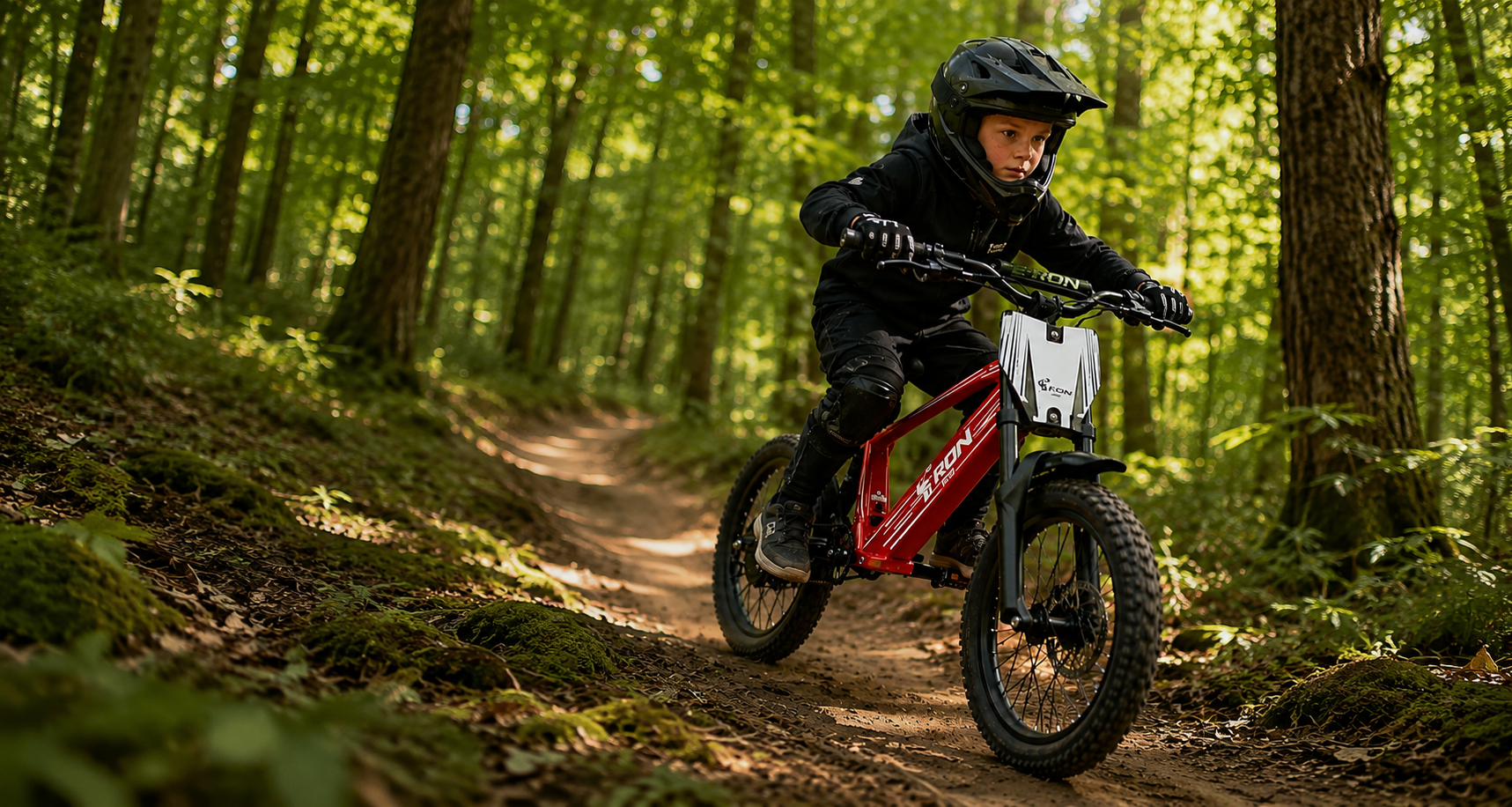 Young rider jumping an E-Ron electric mountain bike on a woodland trail